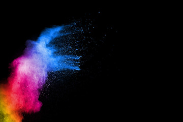 Abstract colorful powder explosion on black background.Freeze motion of dust splash.Painted Holi.