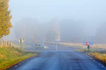 Morning fog at a crossroads on a country road