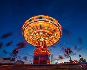 Adrenalinkick auf dem rotierenden Kettenkarussel am Abend