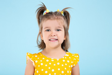 Cute little girl in yellow dress on blue background