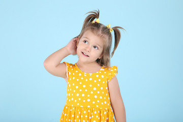 Cute little girl in yellow dress on blue background