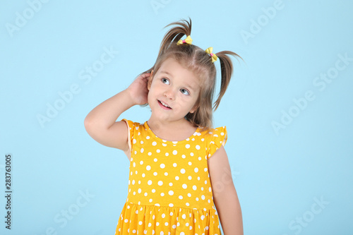 Cute little girl in yellow dress on blue background
