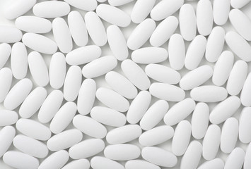 Fototapeta na wymiar White pills (tablets) background. Top view
