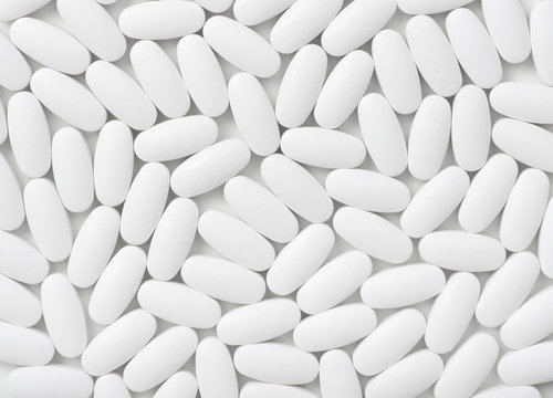 White pills (tablets) background. Top view © Alekss