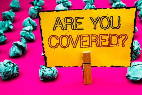 Text sign showing Are You Covered Question. Conceptual photo Have a Security and Health Insurance Medical Care Clothespin hold holding yellow paper black red letters crumpled papers idea