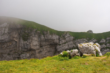 Mangart Saddle in Slovenia in low clouds during the summer. Mangart, also called Mangrt, is the third highest mountain in Slovenia and is situated in the Triglav National Park