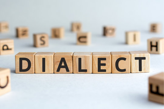 dialect - word from wooden blocks with letters, form of a language dialect concept, random letters around, white  background