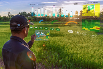 Smart farming with IoT, futuristic agriculture concept : Farmer wears VR or AR glasses while...