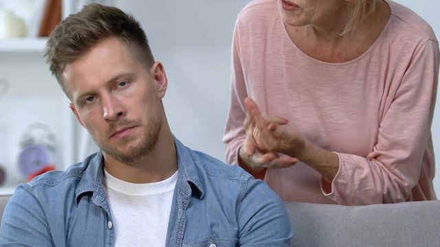 Overprotecting elderly mother giving advices to adult son, extra care and worry