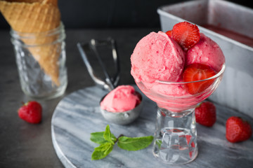 Delicious strawberry ice cream in dessert bowl served on grey table
