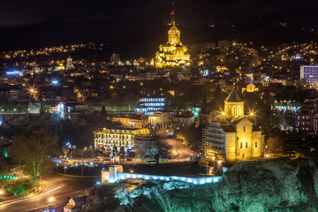 Fototapeta na wymiar Night view of Tbilisi with Sameba (Trinity) Church and other landmarks. Travel.