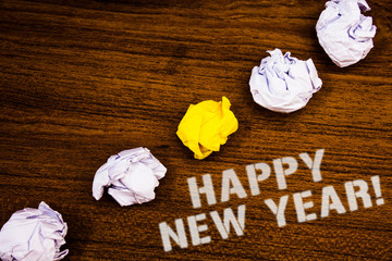 Text sign showing Happy New Year Motivational Call. Conceptual photo Greeting Celebrating Holiday Fresh Start Ideas concepts words on wooden background crumpled papers several tries