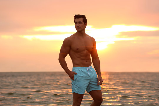 Attractive man in underwear on a beach at sunrise. Stock Photo by ©nickp37  6526577