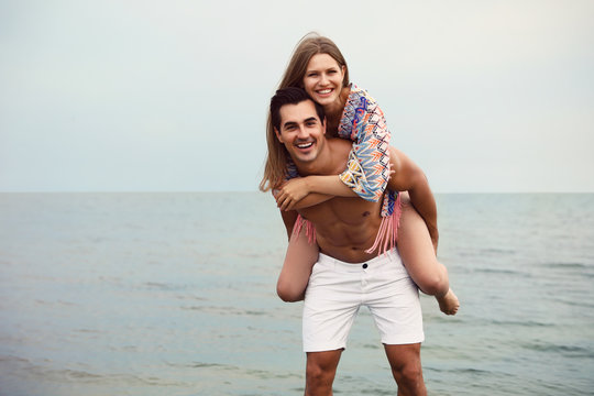 Happy young couple having fun on sea beach