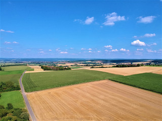 Farmland with country road sky and clouds photographed from above