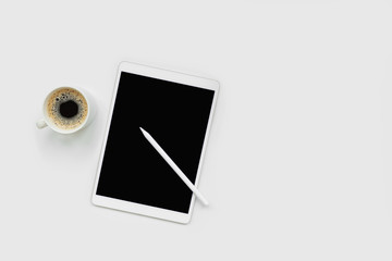 Tablet, pencil and cup of coffee on white desk. Top view. Copy space. Mock-up