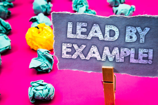 Writing note showing Lead By Example Motivational Call. Business photo showcasing Leadership Management Mentor Organization Words torn paper wooden clip pink background crumbled yellow blue note