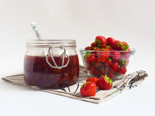 Strawberry jam in a jar on white background