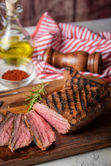 sliced tri tip seak marinated with santa maria sauce  on wooden cutting board