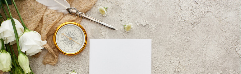 panoramic shot of quill pen on beige sackcloth near white card, golden compass and eustoma flowers on grey textured surface