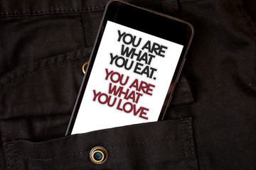 Word writing text You Are What You Eat. You Are What You Love.. Business concept for Start to eat healthy food Cell phone black color frontal pocket show colorful alphabetical character