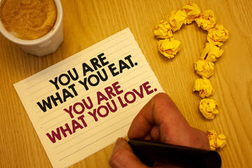 Conceptual hand writing showing You Are What You Eat. You Are What You Love.. Business photo showcasing Start to eat healthy food Wooden desktop hand hold marker page coffee question mark
