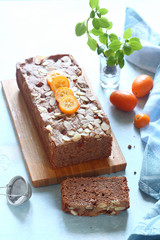 Chocolate Loaf Cake with Candied Kumquats, on light blue background.
