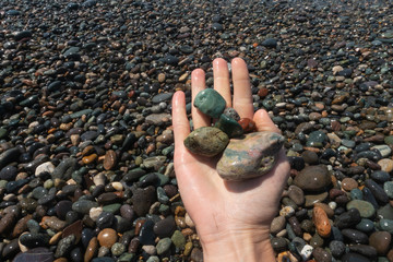 mano le pietre colorate sulla spiaggia estate mare
