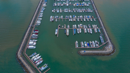 Fototapeta na wymiar Aerial view of yachts and boat berthed in the marina, Yacht parking, marina lot, Yacht and sailboat is moored at the quay.