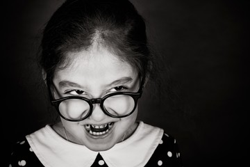 Shooting in the Studio. Portrait of a girl with glasses. The girl is wearing a dress with a white...