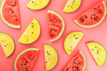 Slices of red and yellow watermelon on a pink background in the form. Minimal food concept idea