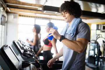 Fototapeta na wymiar Young people running on a treadmill in health club.