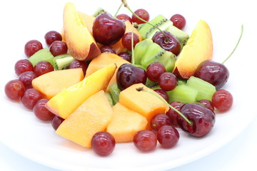 Close up of fresh, colorful fruits on a plate isolated on white background