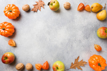 Autumn background with yellow leaves, pumpkins apples pears and nuts. Copy space.