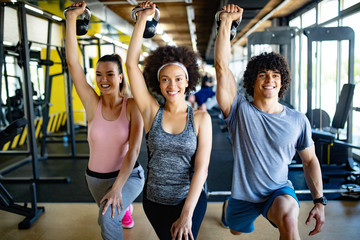 Group of healthy fit people training in gym