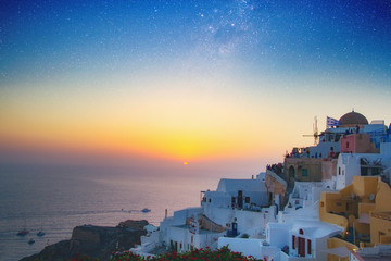 Magnificent view of the mills of the city of Oia on the island of Santorini Greece during a beautiful sunset in the Mediterranean. Love and travel background. Elements of this image furnished by NASA.