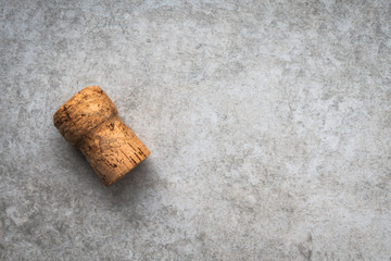 Single champagne cork on a textured grey backgroud with copy space.