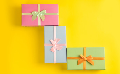 Gift box on sunny yellow background. The concept of the New Year, Christmas, Birthday, Anniversary. Top view. Flatlay.