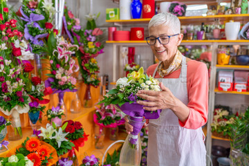 Woman working in flower shop. Smiling Mature Woman Florist Small Business Flower Shop Owner....