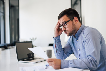 Stressed out and worried overworked businessman in office working under pressure and tight deadline - obrazy, fototapety, plakaty