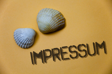 Handwriting text writing Impressum. Concept meaning Impressed Engraved Imprint German statement ownership authorship Grunge ideas messages shells light brown background beach memories thoughts