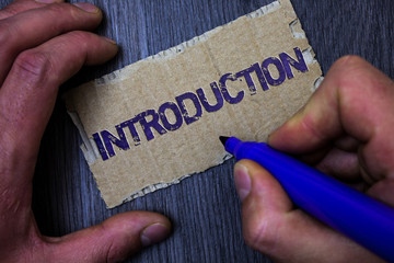 Text sign showing Introduction. Conceptual photo First part of a document Formal presentation to an audience Man working holding blue marker ideas message paperboard wooden background