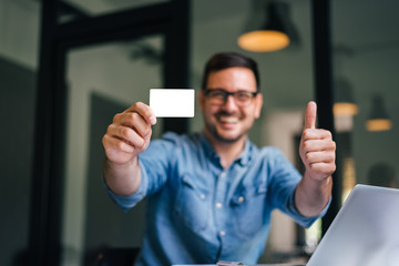 Mock up clipping path background backdrop white size of standard credit card smiling man holding empty credit card showing thumb up for quality of service an customer satisfaction