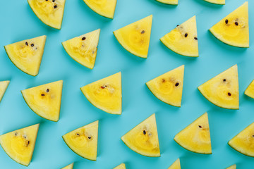 Pattern of slices of fresh slices of red and yellow watermelon on a blue background. Top view