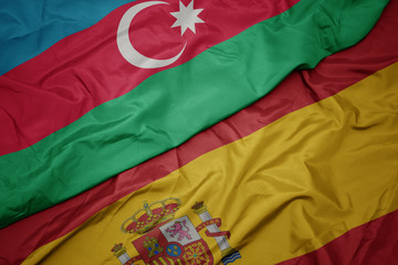 waving colorful flag of spain and national flag of azerbaijan.