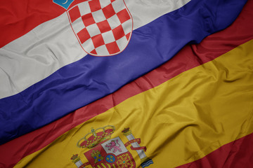 waving colorful flag of spain and national flag of croatia.
