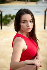 Attractive young woman in red dress outdoors