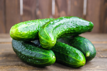 organic cucumbers heap on wooden background soft focus