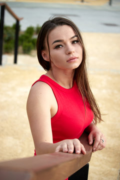 Attractive young woman in red dress outdoors