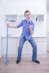 Teenager Boy Mopping The Floor and helps his parents to clean on kitchen